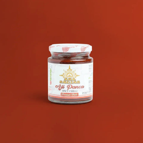 Jar of spicy chilli (Panca) paste on a red background