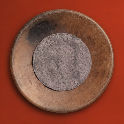 Fresh Blue Corn Tortilla on a textured brown plate surface with a red background