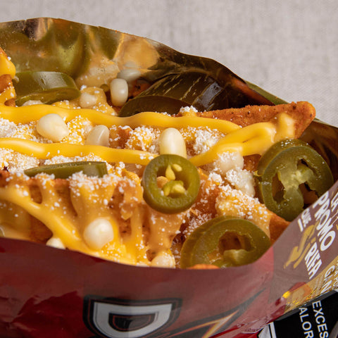 A close up of an open packet of Doritos with cheese, white corn and jalapenos.