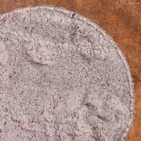 Ble corn tortilla on brown surface.