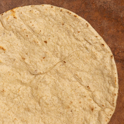 Close-up of a corn tortilla on a wooden surface
