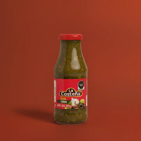 A small bottle of La Costéna green salsa on a red background