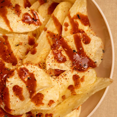 Tortilla chips with a brown sauce on a beige plate