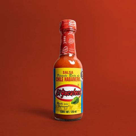 El Yucateco hot sauce bottle on a red background