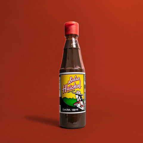 Bottle of Salsa Huichol on a red background