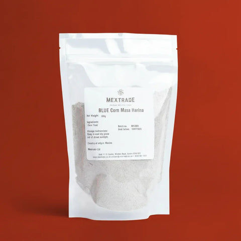 A clear bag of Mextrade Blue Corn Masa Harina package on a red background