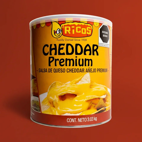 Yellow can of Ricos Cheddar Premium cheese sauce on a red background