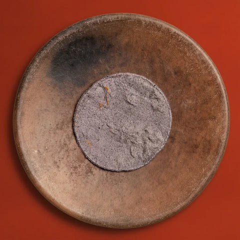 Fresh blue corn tortilla on a wooden plate on a red background