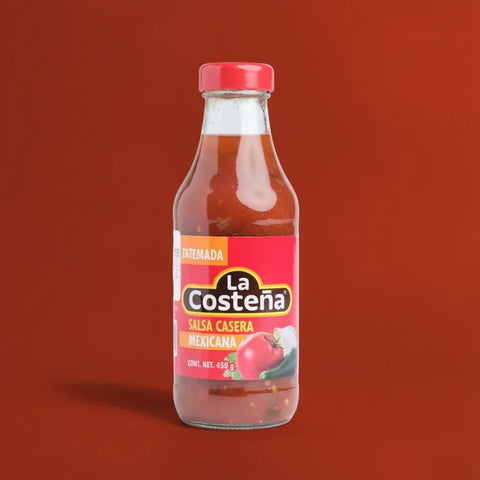 Bottle of La Costena red salsa on a red background