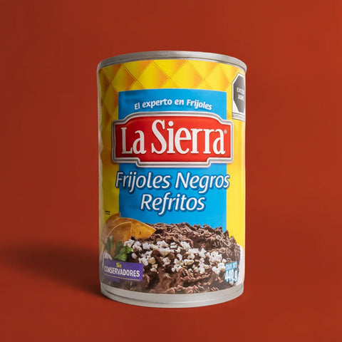 Can of La Sierra Frijoles Negros Refritos on a red background
