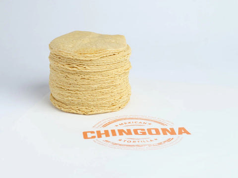 Stack of corn tortillas with a Chingona brand logo on a white background