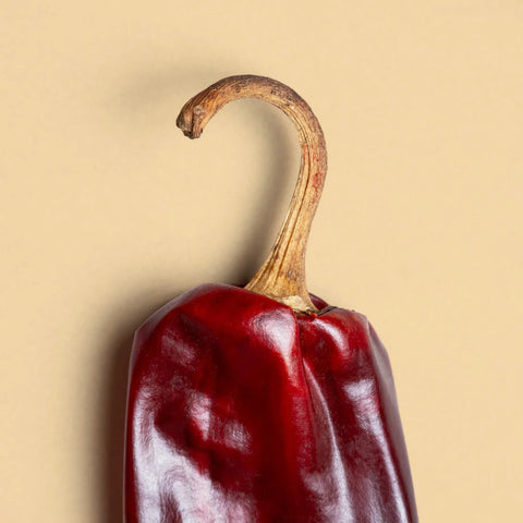 Close-up of the stem of a guajillo pepper on beige background.