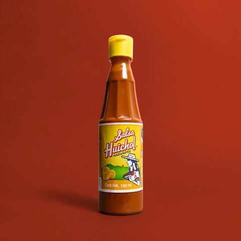 Bottle of Habanero Hot sauce by Huichol on a red background