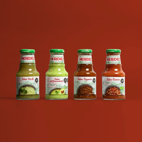 Four bottles of Herdez salsa on a red background