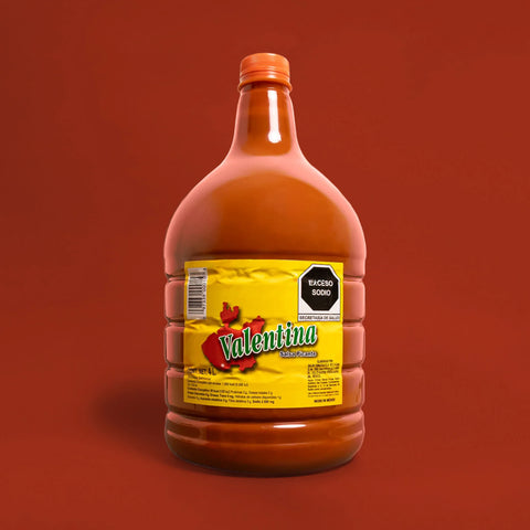 Bottle of Valentina hot sauce on a red background